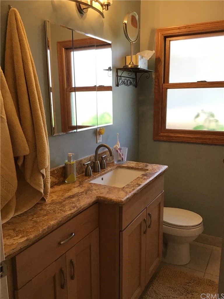 2154 Ostrom Avenue Long Beach, CA 90815 - Photo 21 of 29 a bathroom with a granite countertop sink toilet and mirror