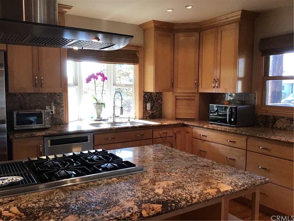 2154 Ostrom Avenue Long Beach, CA 90815 - Photo 4 of 29 a kitchen with stainless steel appliances kitchen island granite countertop a stove a sink and a microwave