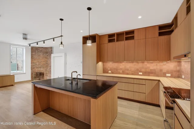 a kitchen with stainless steel appliances granite countertop a sink and a refrigerator
