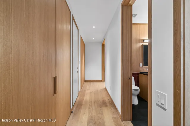 a view of a hallway with wooden floor and entryway