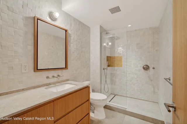a bathroom with a granite countertop sink a toilet and shower