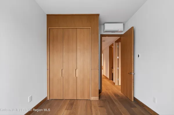 an empty room with wooden floor and closet