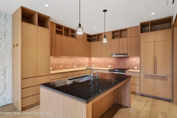 a kitchen with stainless steel appliances granite countertop a sink a stove and a refrigerator