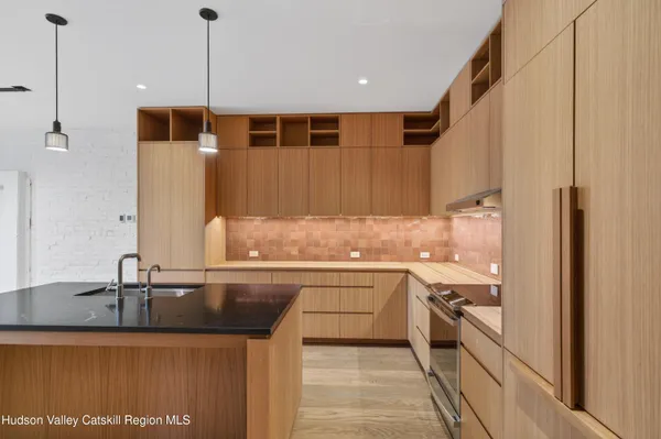 a kitchen with stainless steel appliances granite countertop a sink and a refrigerator