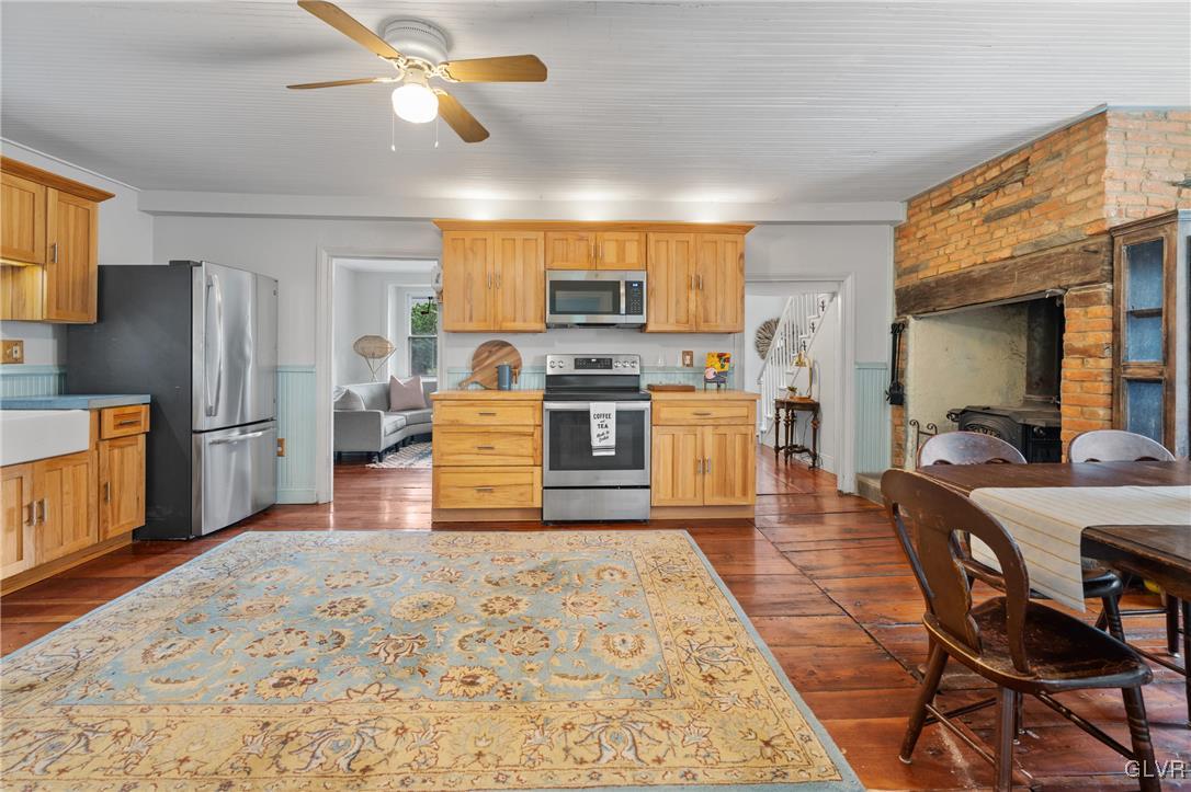 3225 Jordan Road Orefield, PA 18069 - Photo 13 of 50 a kitchen with stainless steel appliances granite countertop a stove top oven a sink dishwasher a dining table and chairs with wooden floor