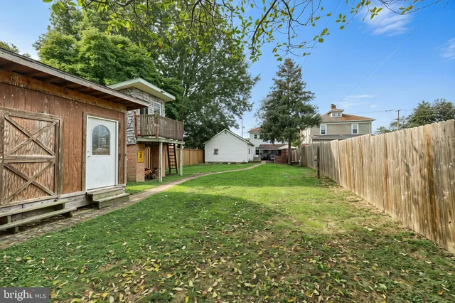 a view of a house with backyard and a tree