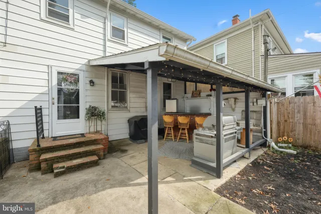a backyard of a house with barbeque oven table and chairs