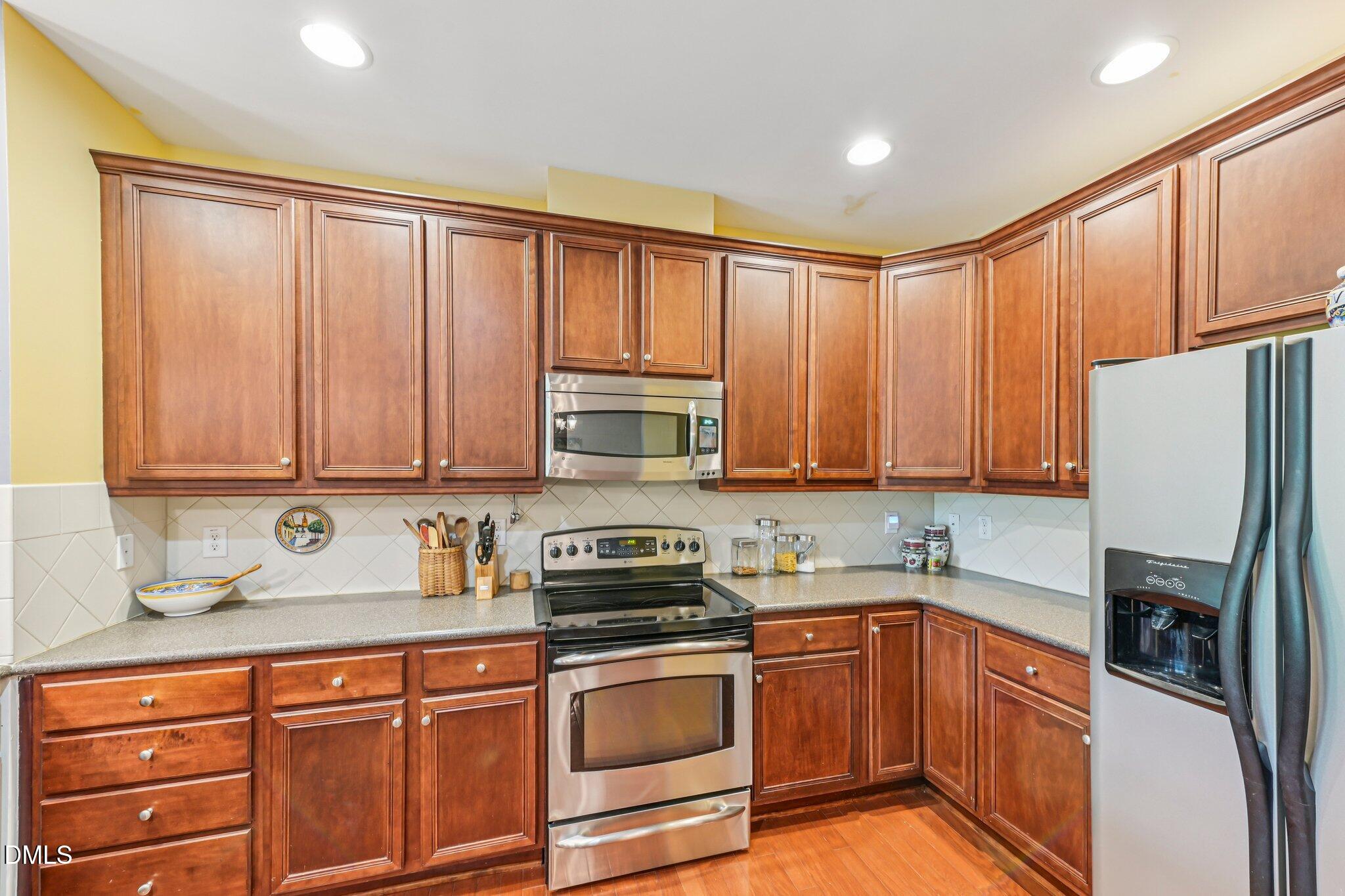 10411 Rosegate Court, Unit 205 Raleigh, NC 27617 - Photo 19 of 38 a kitchen with stainless steel appliances granite countertop a refrigerator a sink dishwasher stove with cabinets