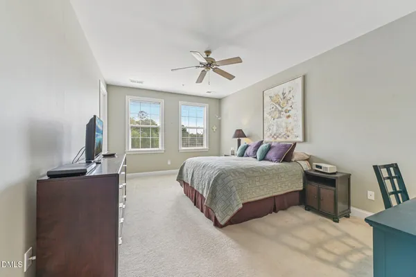 a bedroom with a large bed and a chandelier