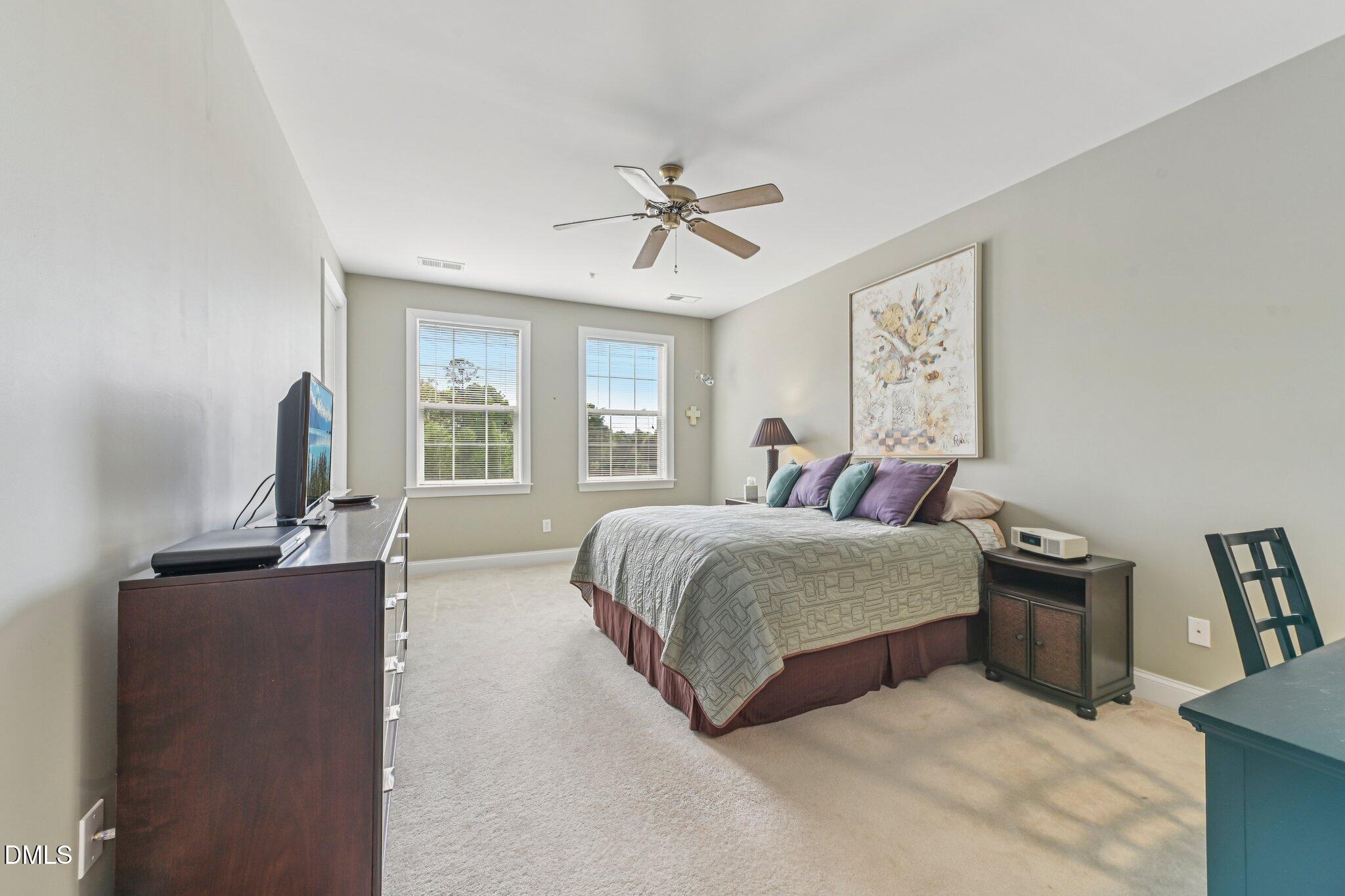 10411 Rosegate Court, Unit 205 Raleigh, NC 27617 - Photo 8 of 38 a bedroom with a large bed and a chandelier