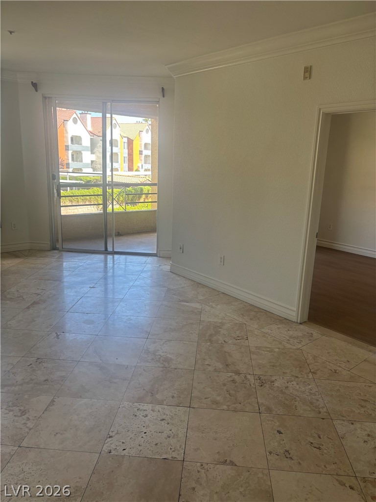 210 East Flamingo Road, Unit 123 Las Vegas, NV 89169 - Photo 3 of 17 Sliding glass doors lead to a private balcony from this spacious tile-floored living area.