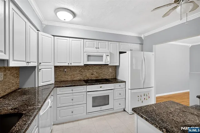 a kitchen with granite countertop a stove and a refrigerator