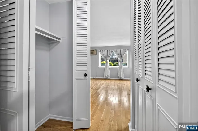 a view of a hallway with wooden floor and windows