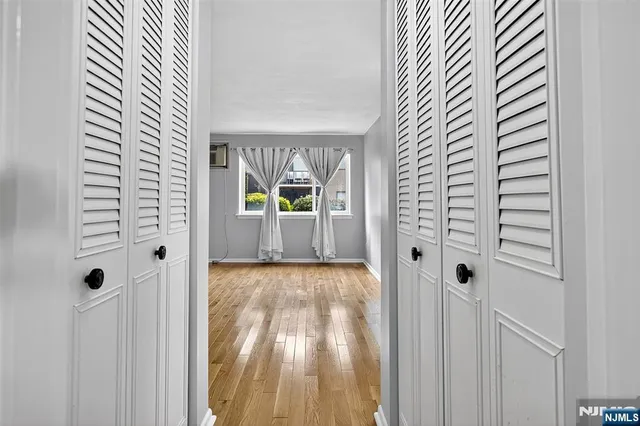 a view of a hallway with wooden floor and dining room