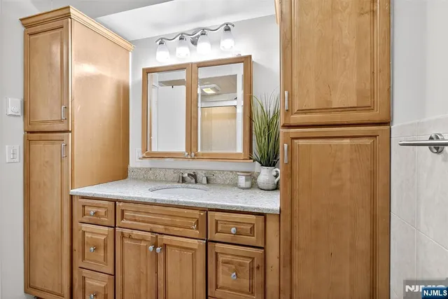 a bathroom with a granite countertop sink and a mirror