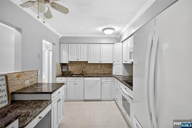 a kitchen with stainless steel appliances granite countertop a stove top oven a sink a counter space and cabinets
