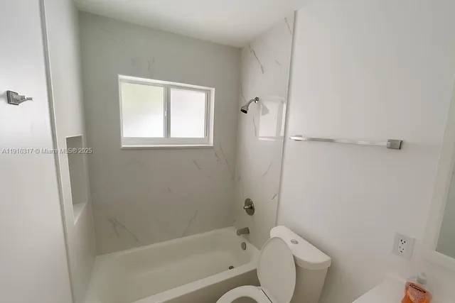 a bathroom with a toilet and a bathtub