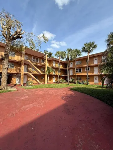 a view of a big room with a big yard and large trees