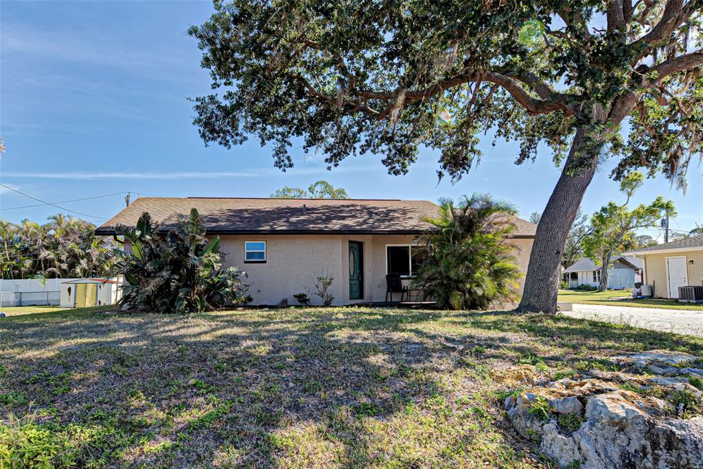 a view of a house with a tree in front of it