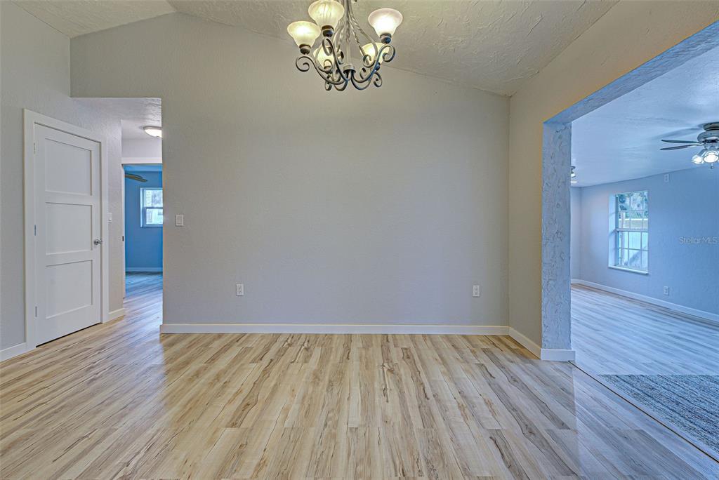 3187 Galiot Road Venice, FL 34293 - Photo 11 of 46 wooden floor in an empty room with a window