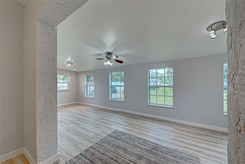 3187 Galiot Road Venice, FL 34293 - Photo 19 of 46 a view of an empty room with window and wooden floor