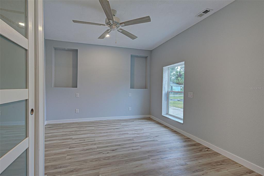 3187 Galiot Road Venice, FL 34293 - Photo 27 of 46 wooden floor in an empty room with a window