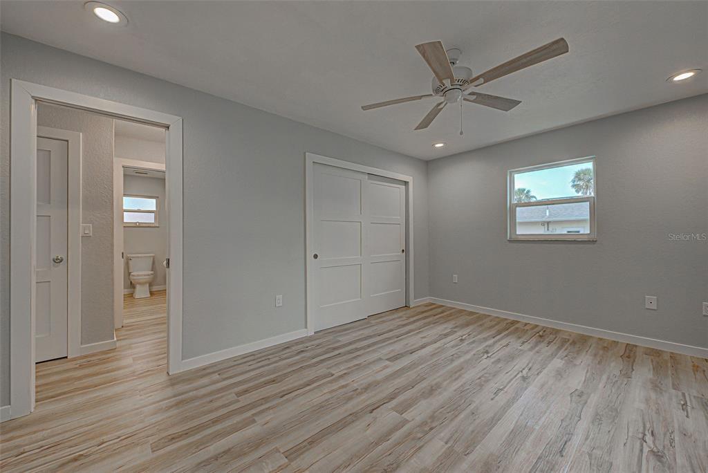 3187 Galiot Road Venice, FL 34293 - Photo 34 of 46 a view of an empty room with wooden floor and a ceiling fan