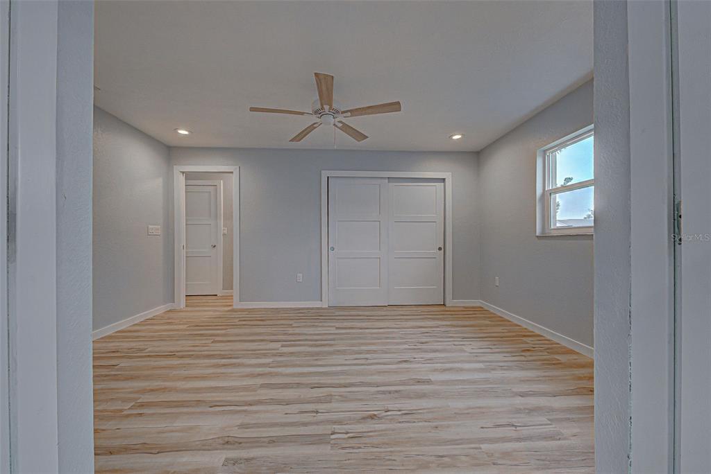 3187 Galiot Road Venice, FL 34293 - Photo 35 of 46 a view of empty room with wooden floor and fan