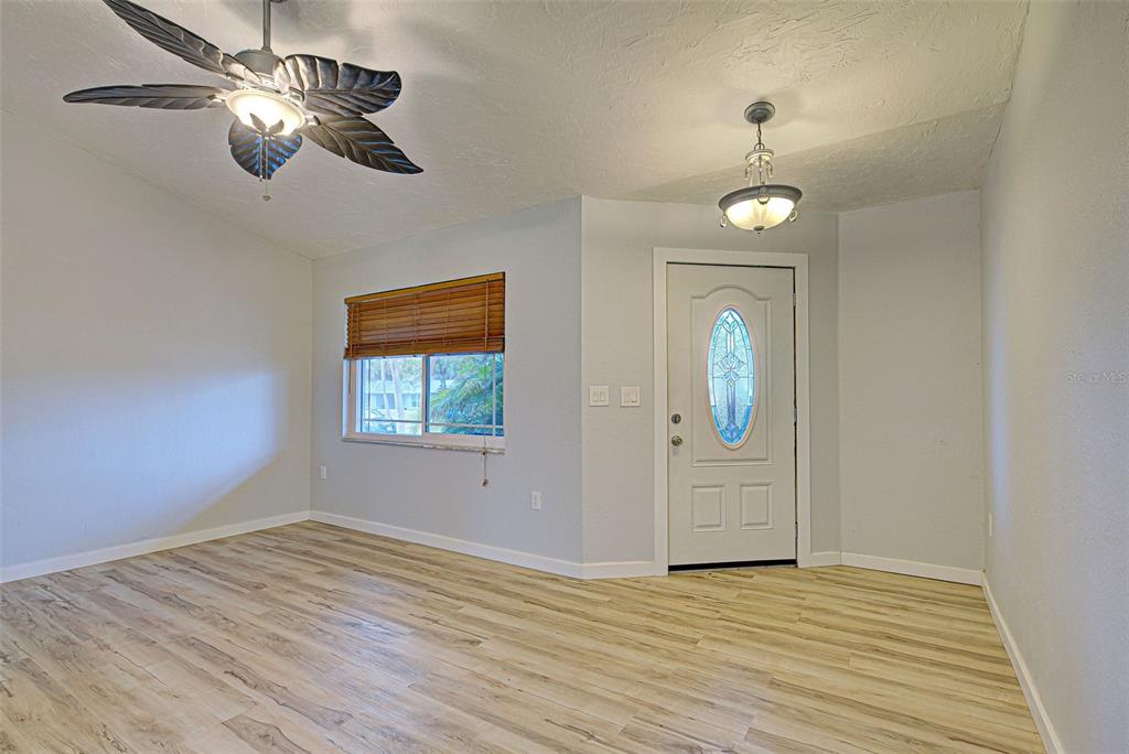 3187 Galiot Road Venice, FL 34293 - Photo 4 of 46 wooden floor in an empty room with a window