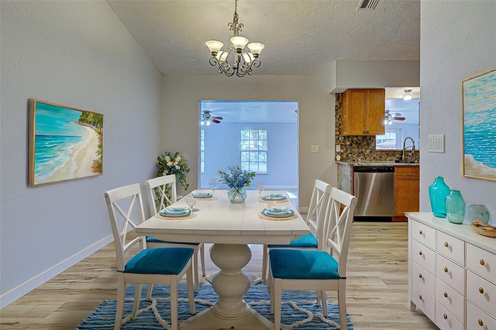 3187 Galiot Road Venice, FL 34293 - Photo 9 of 46 a view of a dining room with furniture a chandelier and wooden floor