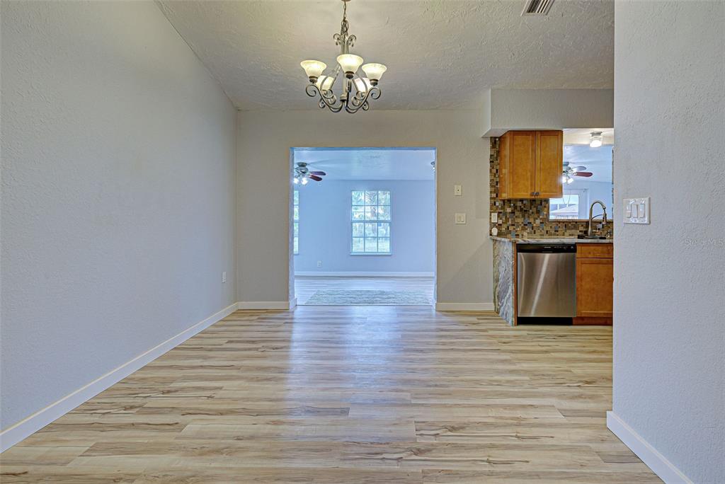 3187 Galiot Road Venice, FL 34293 - Photo 10 of 46 a view of a hallway with wooden floor and a kitchen