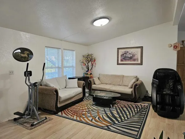 a living room with furniture a rug and a floor to ceiling window