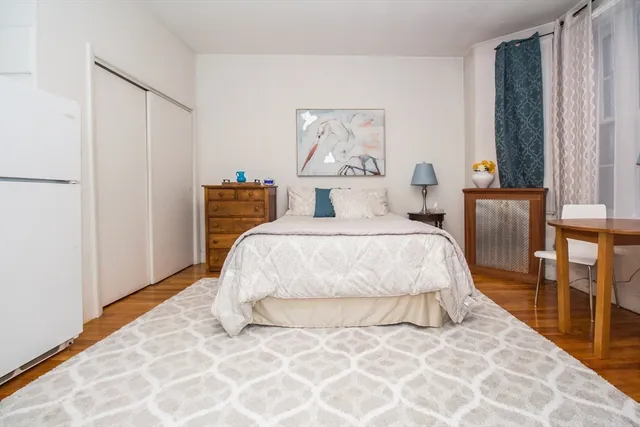 a bedroom with a bed and a painting on the wall