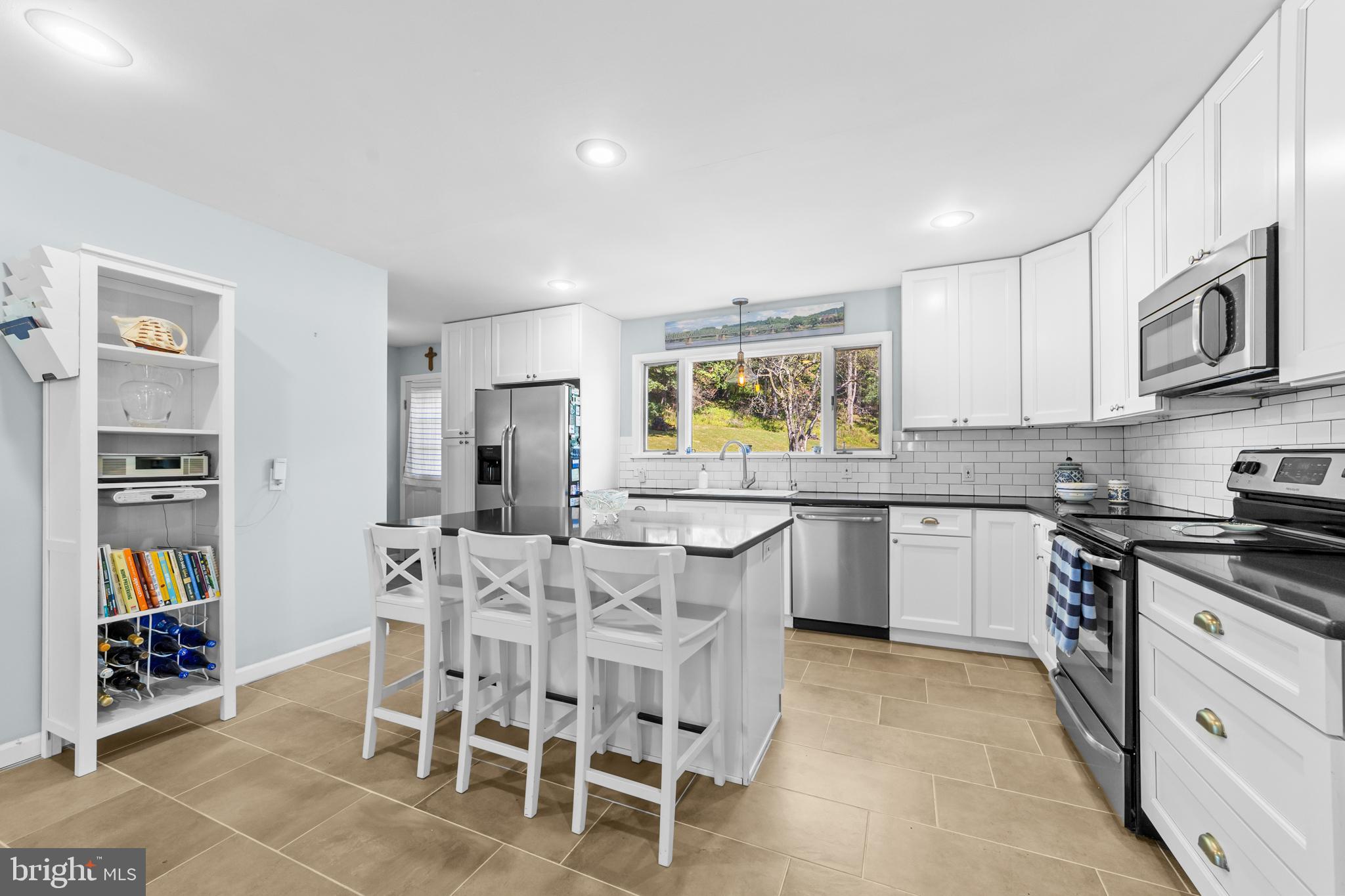 72 Poor Farm Road Pennington, NJ 08534 - Photo 13 of 38 a kitchen with stainless steel appliances kitchen island granite countertop a stove a sink a dining table and chairs
