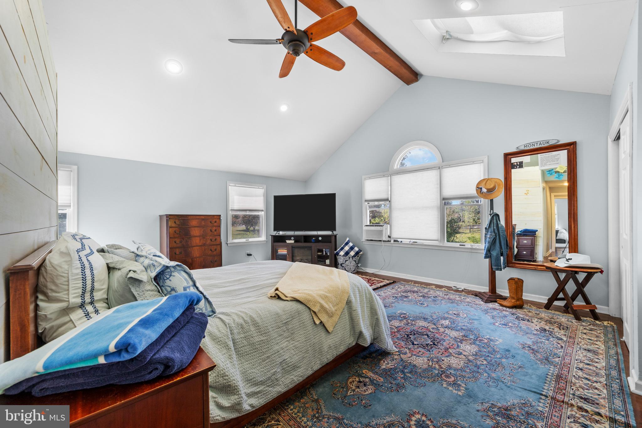 72 Poor Farm Road Pennington, NJ 08534 - Photo 29 of 38 a spacious bedroom with a bed a flat screen tv and windows