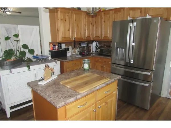 a kitchen with stainless steel appliances granite countertop a refrigerator a sink and a stove