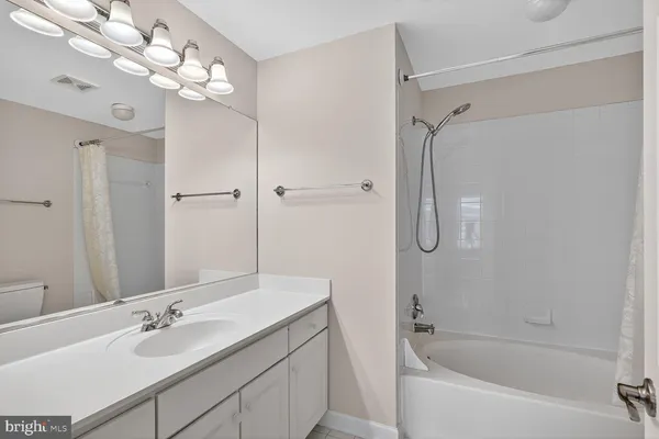a bathroom with a tub shower sink vanity granite and shower