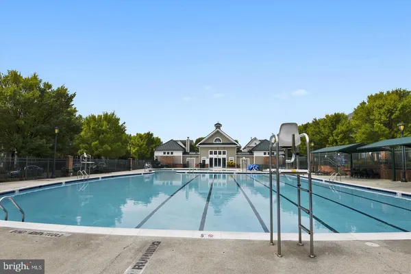 a view of a swimming pool with a patio and a yard