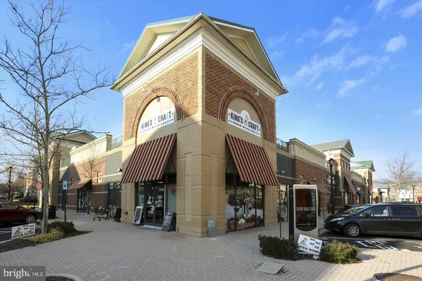 a front view of a building with retail shops and traffic signal