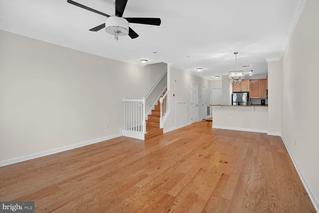 a view of a kitchen with wooden floor and a ceiling fan