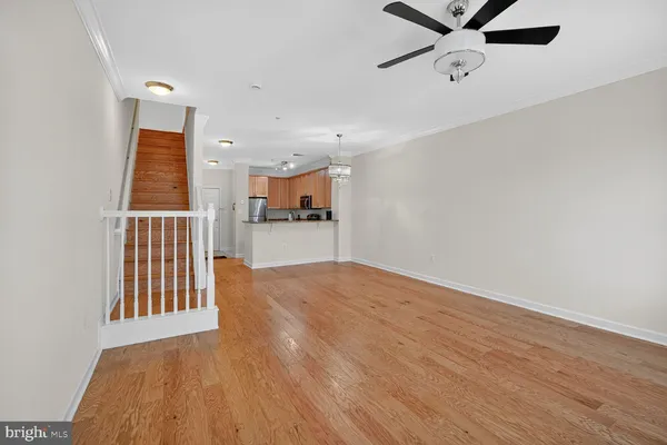 an empty room with wooden floor cabinet and windows