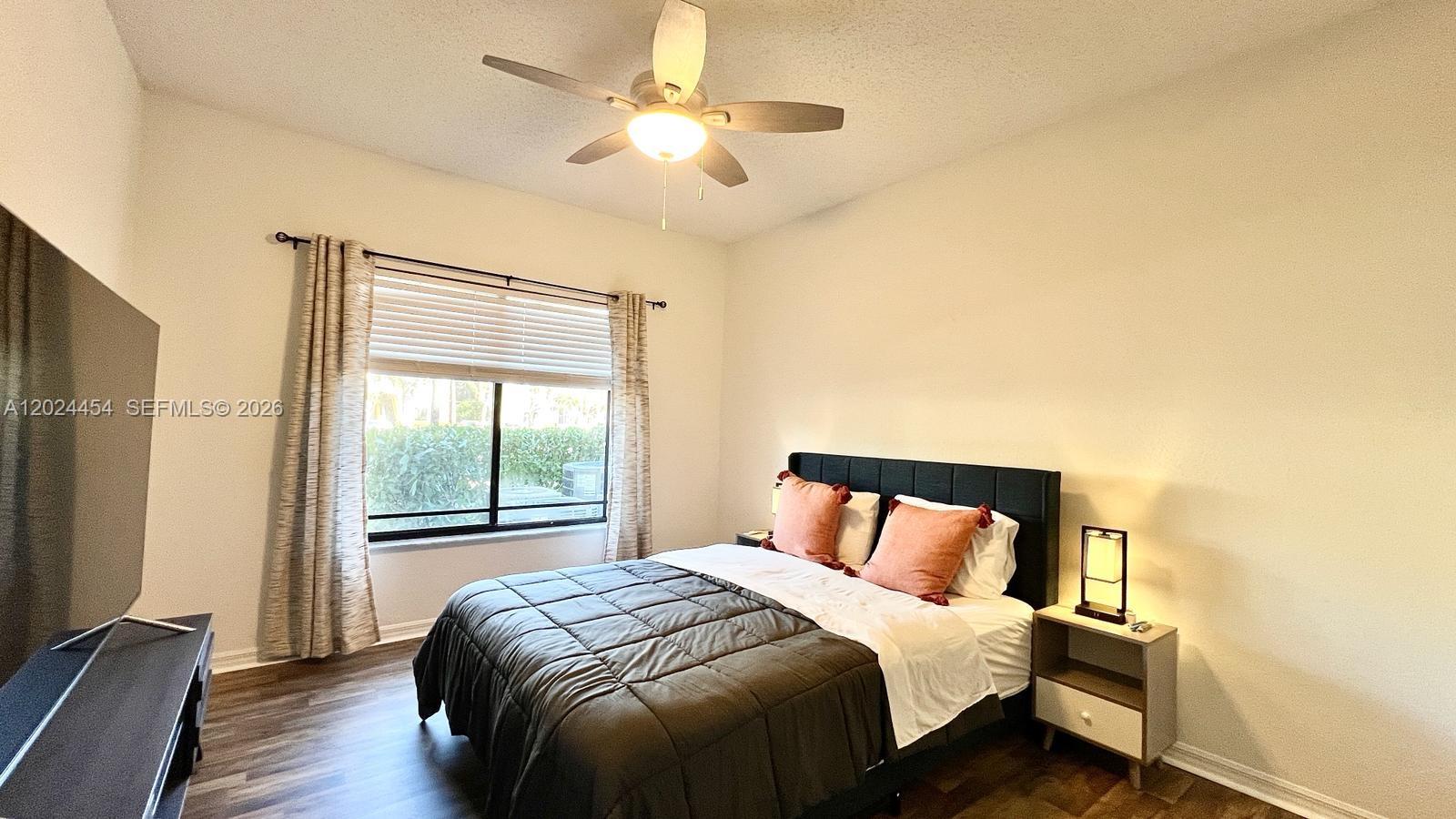 2727 Anzio Court, Unit 106 Palm Beach Gardens, FL 33410 - Photo 20 of 43 a bedroom with a large bed and a tv