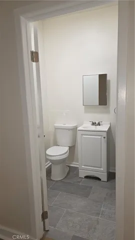 a white toilet sitting next to a white cabinet
