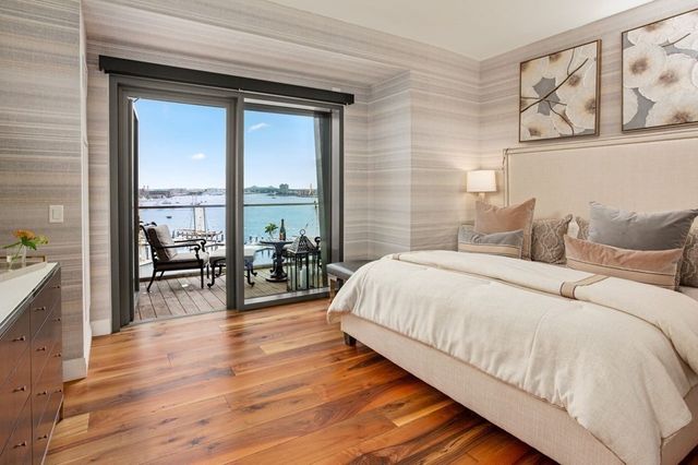 a large bedroom with wooden floor and furniture