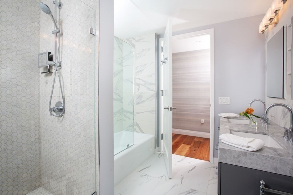 300 Pier 4 Blvd., Unit 8N Boston, MA 02210 - Photo 18 of 37 a bathroom with a granite countertop sink a mirror and a bathtub