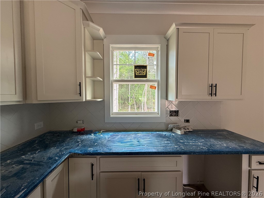 154 Ridge Stone Drive Autryville, NC 28318 - Photo 6 of 17 a kitchen with granite countertop white cabinets and a window