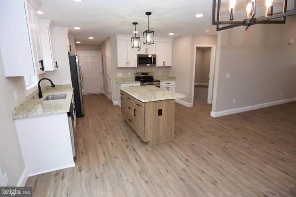 a kitchen with kitchen island a stove a sink and a refrigerator