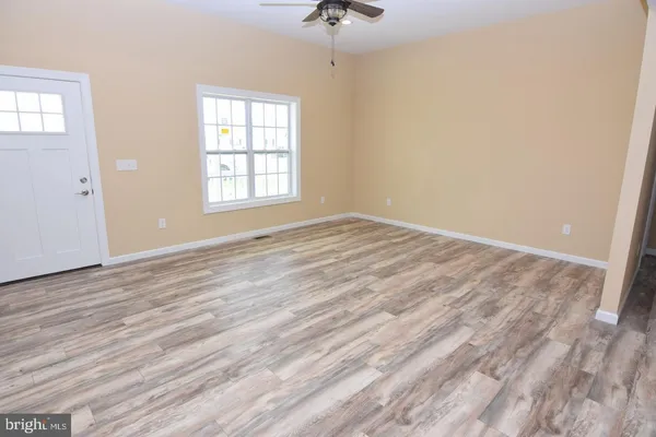 wooden floor in an empty room with a window