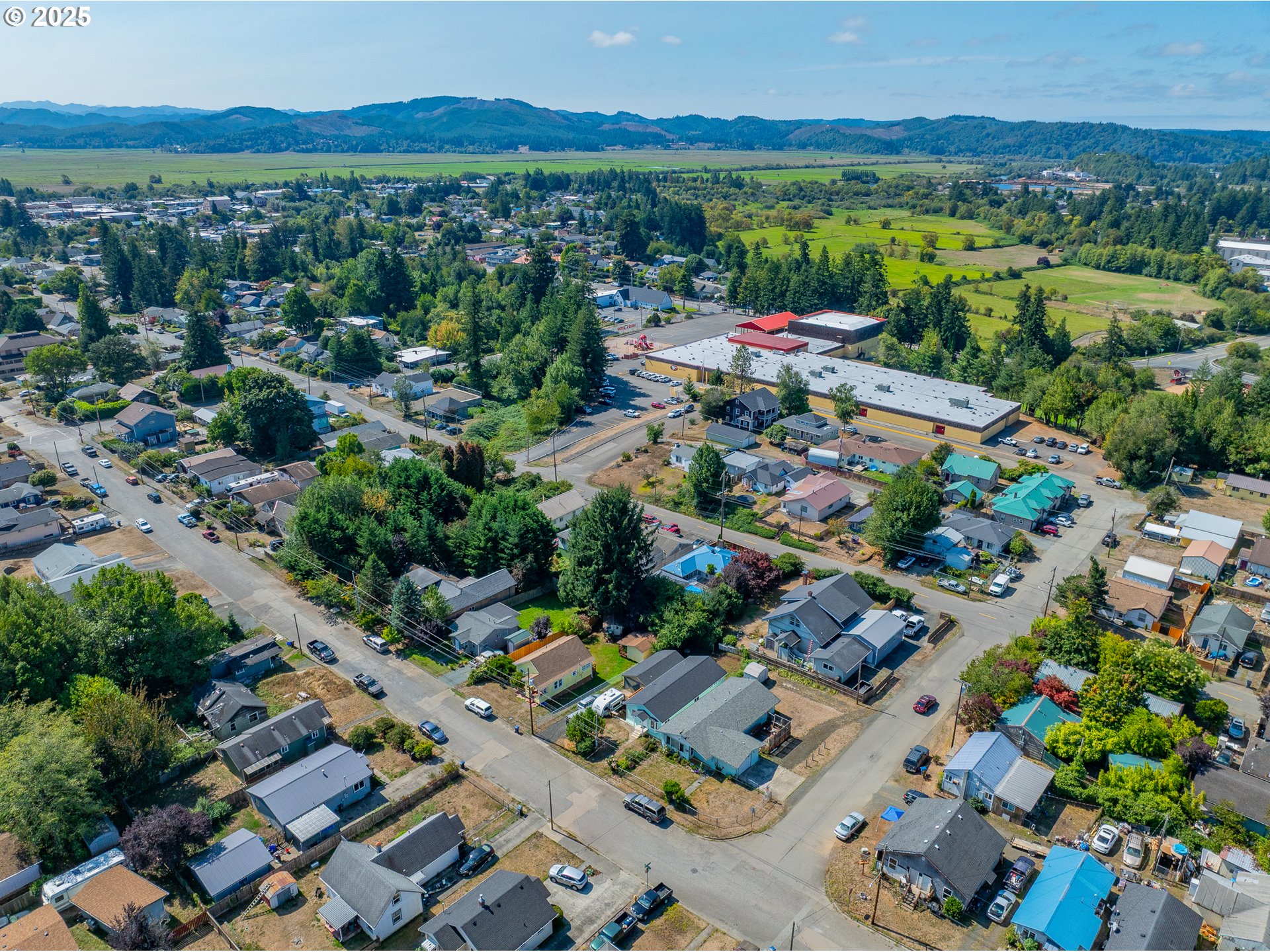 1175 North Dean Street Coquille, OR 97423 - Photo 34 of 34 an aerial view of a city with lots of residential buildings and mountain view in back