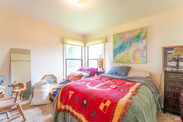 a bedroom with a bed and a painting on the wall